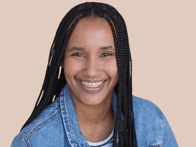 Candyce Denise smiling in a denim jacket, a multi-instrumentalist blending classical, jazz, R&B, and rap in innovative music.