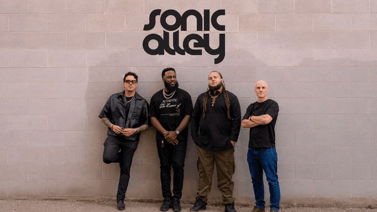 Sonic Alley band members standing beneath the Sonic Alley logo against a brick wall.