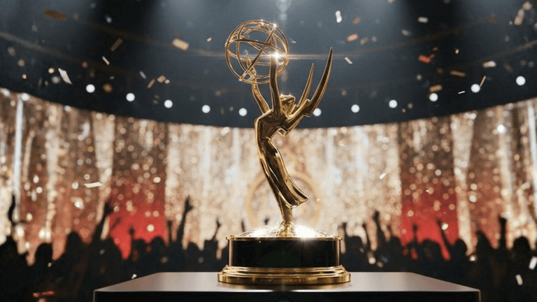 Golden Emmy trophy on stage with a cheering audience and sparkling backdrop