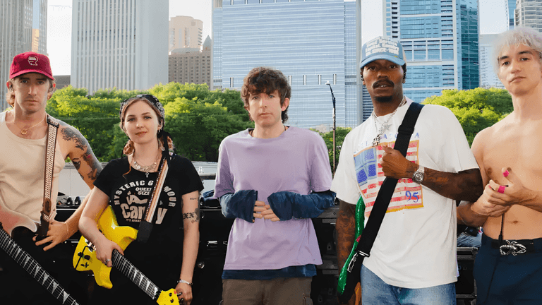 Five musicians pose outside with guitars in front of a cityscape background