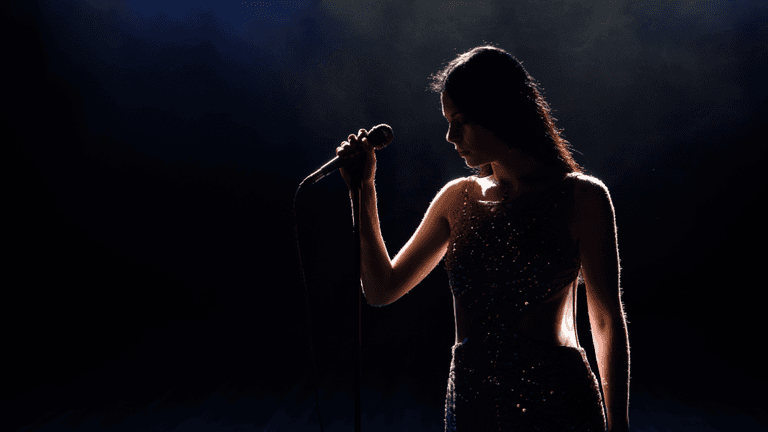Silhouette of a singer holding a microphone under dramatic stage lighting
