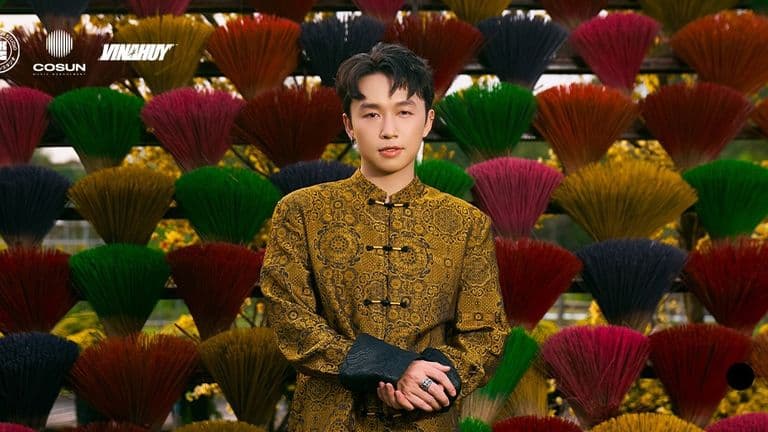 VINAHUY standing against a colorful backdrop of incense sticks, showcasing his unique style.
