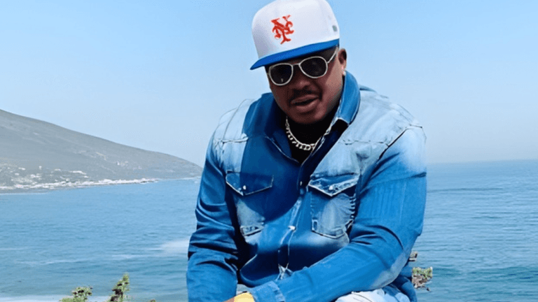 Freddy Will, artist and author, confidently poses by the ocean, symbolizing his blend of creativity, philanthropy, and Afropolitan culture.